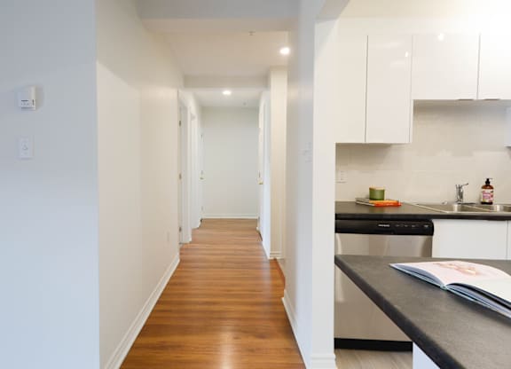 A kitchen with white cabinets and a black countertop.