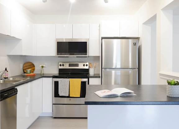 A modern kitchen with a stainless steel refrigerator and a black oven.