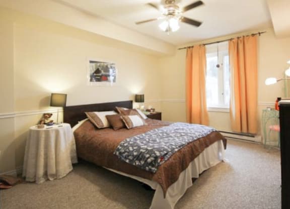 A bedroom with a large bed and a ceiling fan.