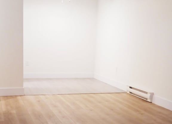A room with a ceiling fan and wooden flooring.
