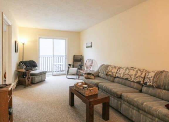 A living room with a couch, chair, and table.