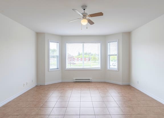 Empty room with a ceiling fan and tiled floor.