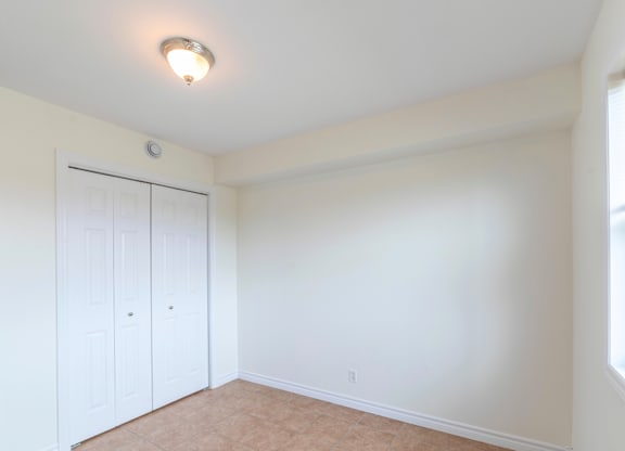 A room with a white door and a brown floor.