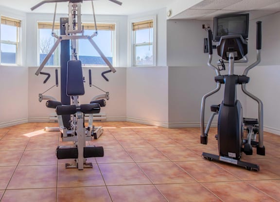 A home gym with a treadmill and a stationary bike.