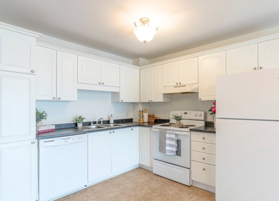 A kitchen with white cabinets and appliances.