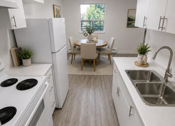 A kitchen with white appliances and a dining table with chairs.