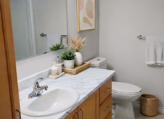 A bathroom with a white sink and a toilet.