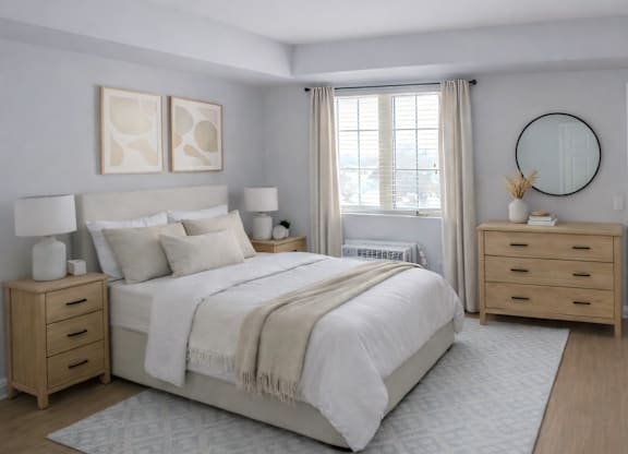 A bedroom with a large bed, two nightstands, and a round mirror on the wall.