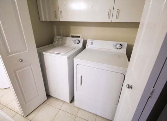 A white washing machine and dryer in a small laundry room.