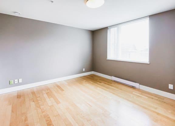 A room with a wooden floor and a window.