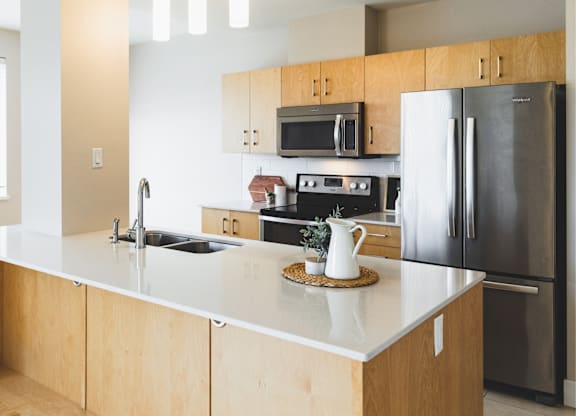 A modern kitchen with wooden cabinets and stainless steel appliances.