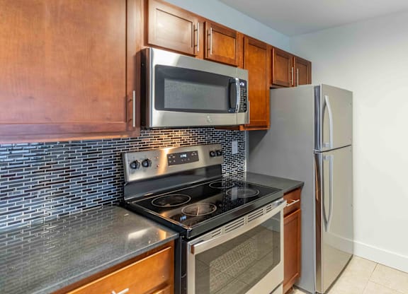 A kitchen with a stove, oven, microwave, and refrigerator.