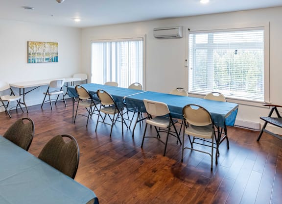 A room with a long table and chairs.