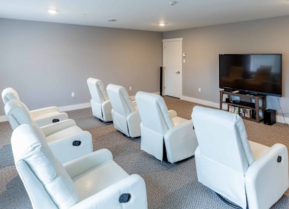 A row of white recliner chairs are lined up in a room.