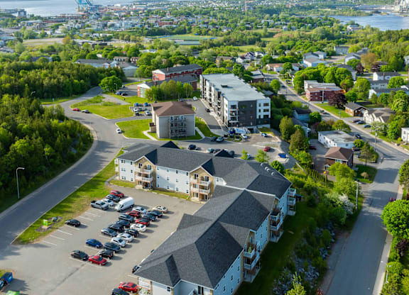 A parking lot in front of a building with a large body of water in the background.