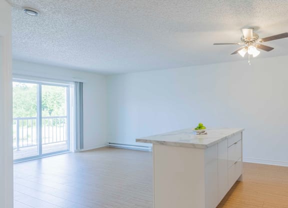 A kitchen with a marble countertop and a ceiling fan.
