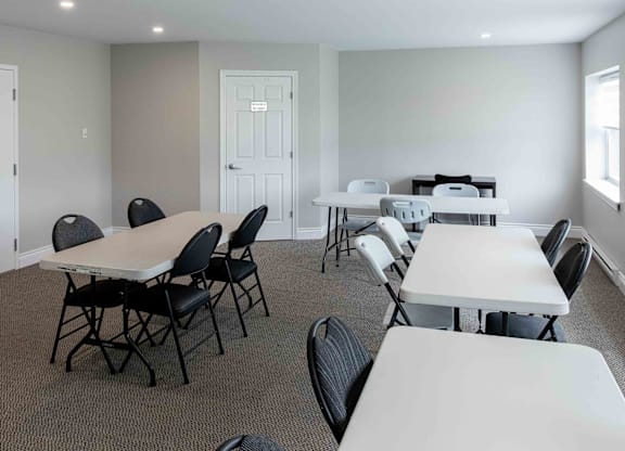 A room with tables and chairs and a door with number 459 on it.