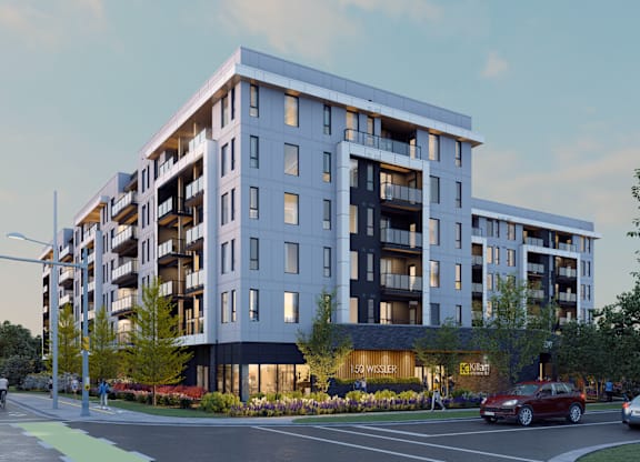 A modern apartment building with a parking lot in front.