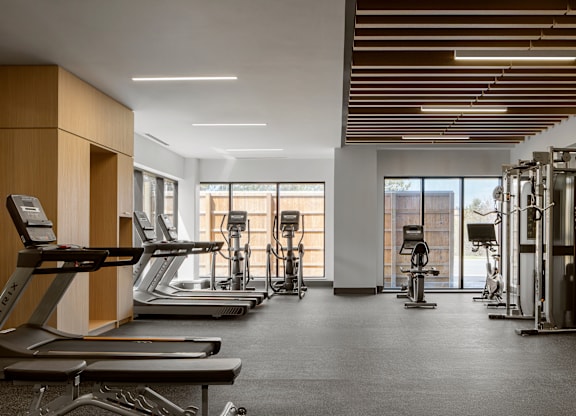 A gym with treadmills, elliptical machines, and other exercise equipment.