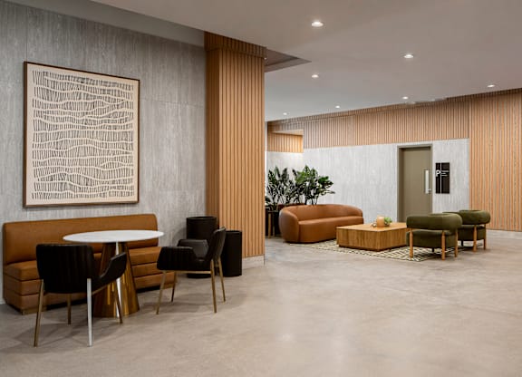 A modern living room with a large abstract painting on the wall and a variety of seating options.