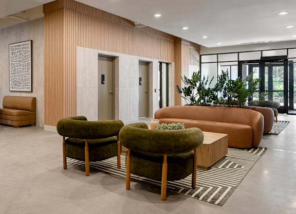 A modern living room with a green couch and a brown armchair.