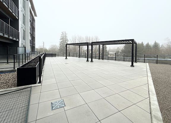 A patio with a metal railing and a drain in the middle.