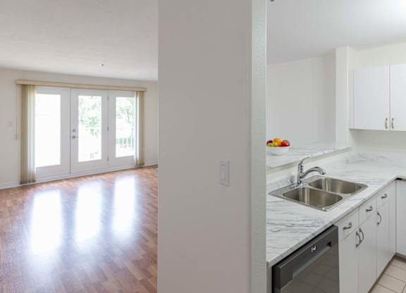 A kitchen with white cabinets and a marble countertop.