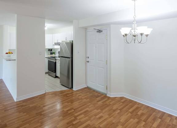 A kitchen with a refrigerator, oven, and sink.
