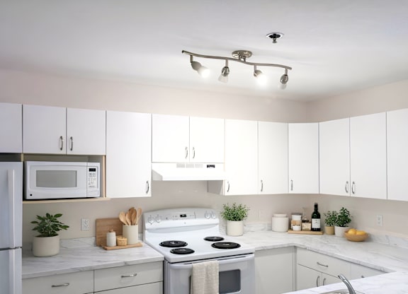 A kitchen with white cabinets and a white fridge.