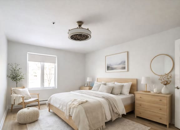 A bedroom with a large bed, a chair, and a plant.
