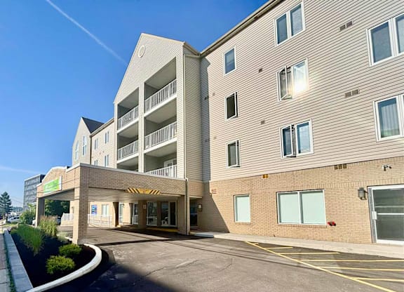 A modern building with a parking lot in front.