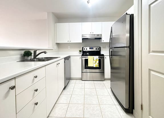 A modern kitchen with white cabinets and a stainless steel refrigerator.