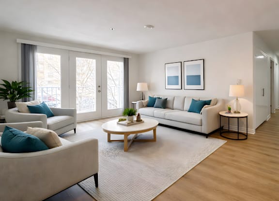 A living room with a white couch, a coffee table, and a plant.