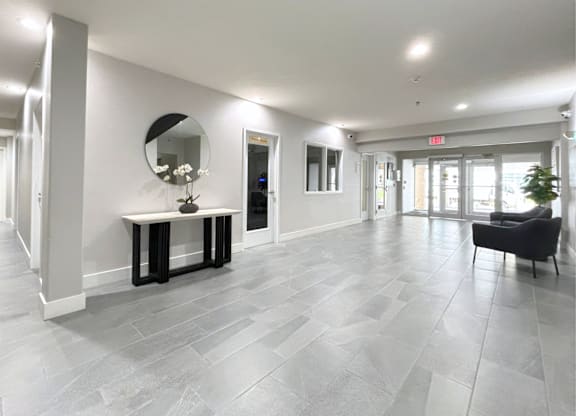 A spacious room with a bench and a mirror.