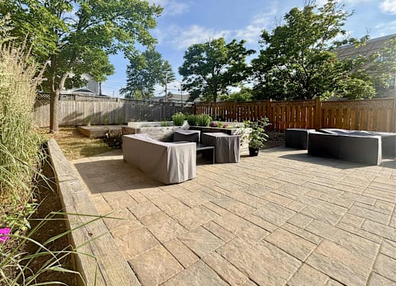 A backyard with a patio and a fence.