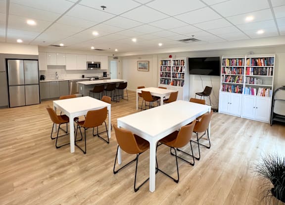 A kitchen with a dining table and chairs.