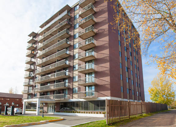 A tall apartment building with balconies on each floor.