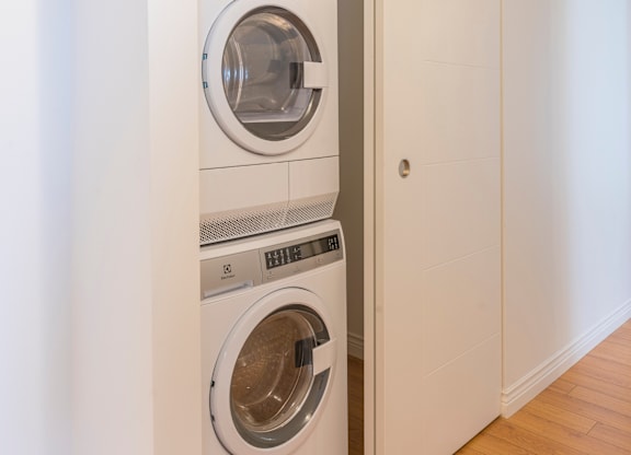 A white washing machine is placed in a small room.