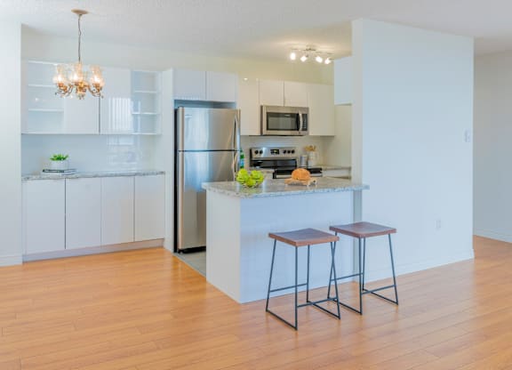 A kitchen with white cabinets and a wooden island.