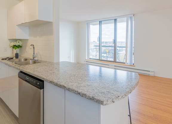A kitchen with a granite countertop and stainless steel appliances.