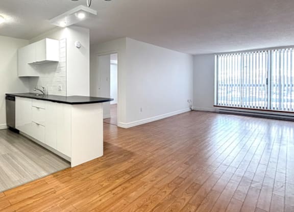 A spacious kitchen with white cabinets and a black countertop.