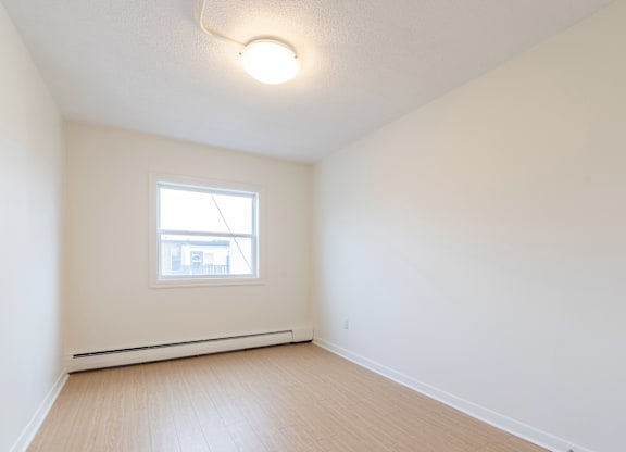 A room with a window and a white ceiling.