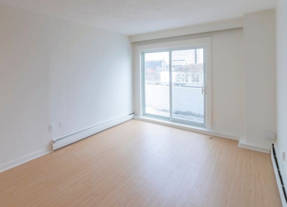 Empty room with a sliding glass door leading to a balcony.