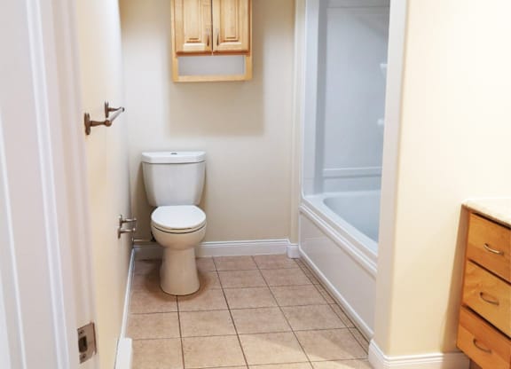 A white toilet sits in a bathroom next to a white door.