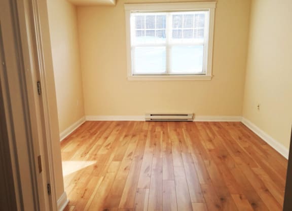 A room with wooden flooring and a window.