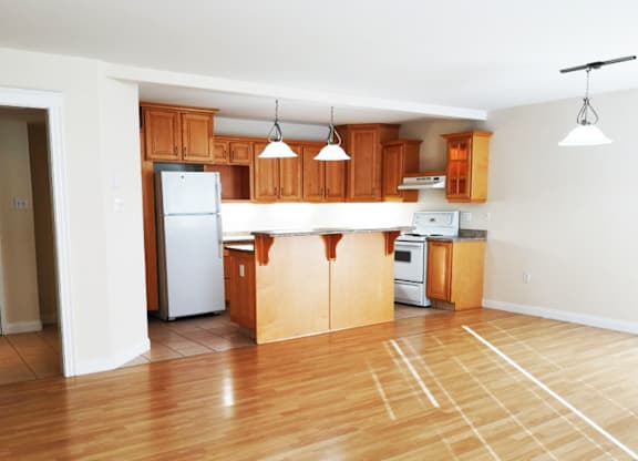 A kitchen with wooden cabinets and a white refrigerator.