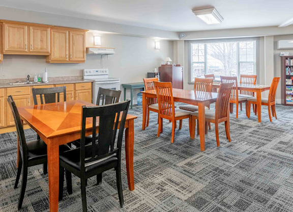 A kitchen with a dining table and chairs.