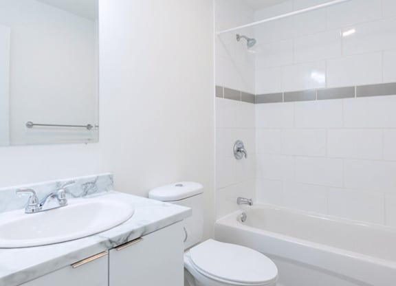 A white bathroom with a sink, toilet, and bathtub.