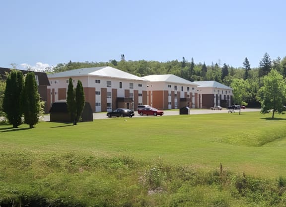 A large white building with a green lawn in front.