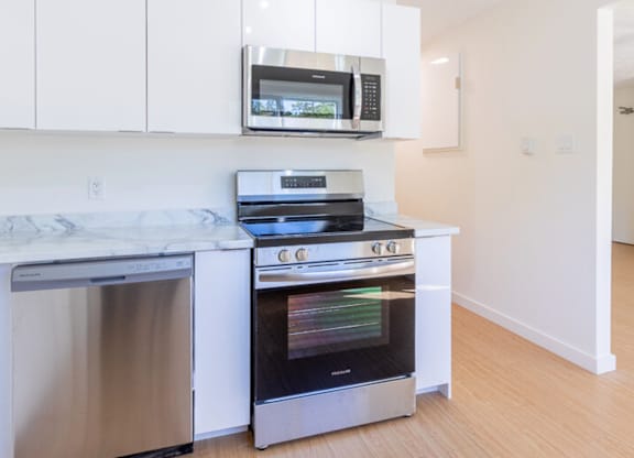 A modern kitchen with a stainless steel oven and microwave above it.
